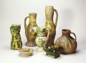 Medieval table and kitchen pots, white central jug is French, 1260-1350, others (incl. facemask) made in London area 13-14<sup>th</sup> centuries - &copy; Museum of London